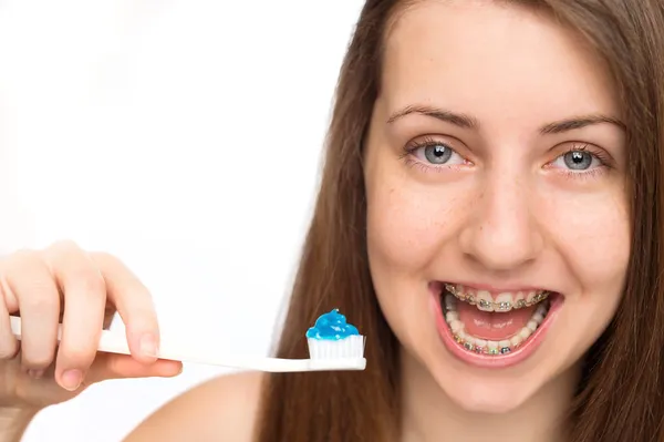 Menina com aparelho segurando escova de dentes — Fotografia de Stock