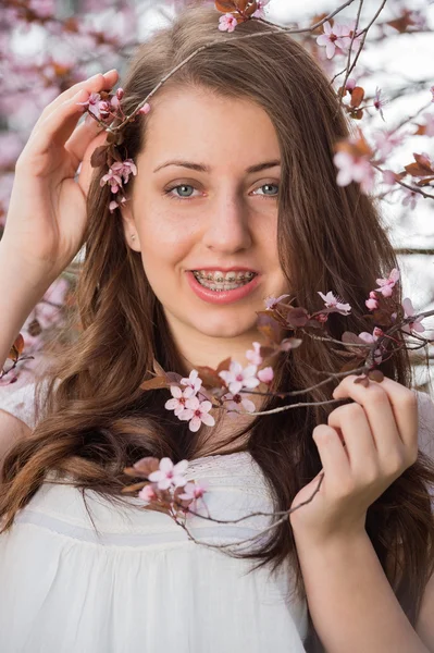 Flicka anläggning blommande trädgren — Stockfoto