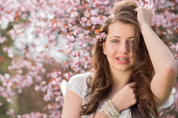 Meisje poseren in de buurt van bloeiende boom — Stockfoto