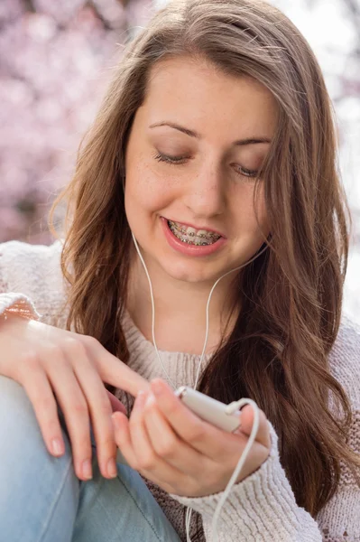 Estudiante con aparato ortopédico escuchando música — Foto de Stock