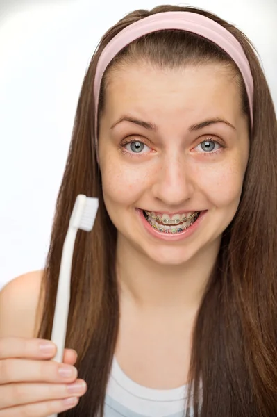 Mädchen mit Zahnspange zeigt Zahnbürste Stockfoto