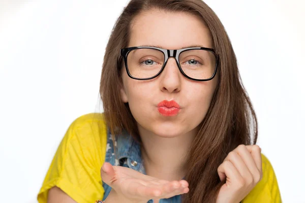 Girl in geek glasses blowing kiss Stock Image