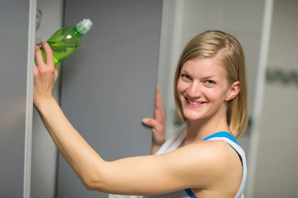 Femme mettant bouteille dans le casier — Photo