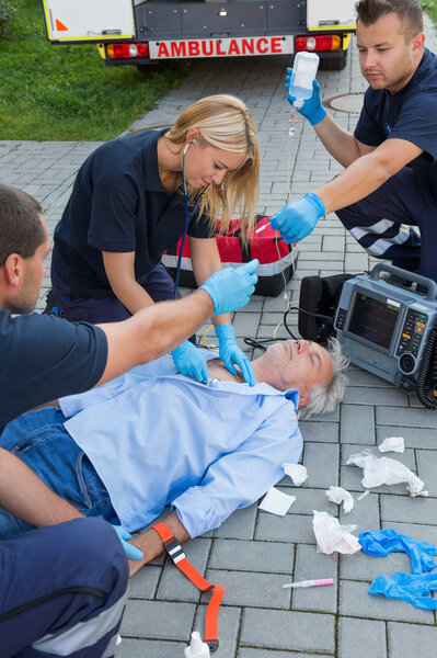 Paramedics examining man