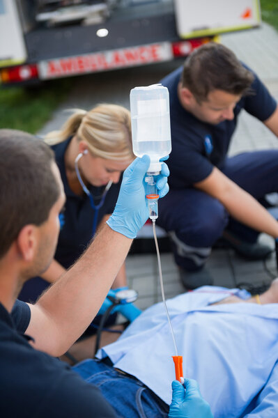 Paramedic team preparing drip for patient