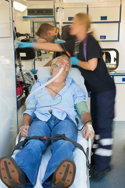 Paramedical team treating patient on stretcher — Stock Photo, Image