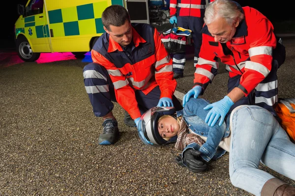 Paramedics helping driver lying on road — Stock Photo, Image