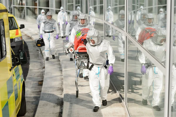 Equipo médico de riesgo biológico caminando hacia la construcción —  Fotos de Stock