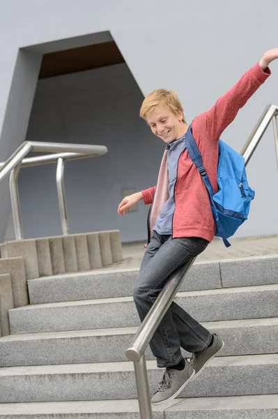 Student sliding down railing on stairway — Stock Photo, Image