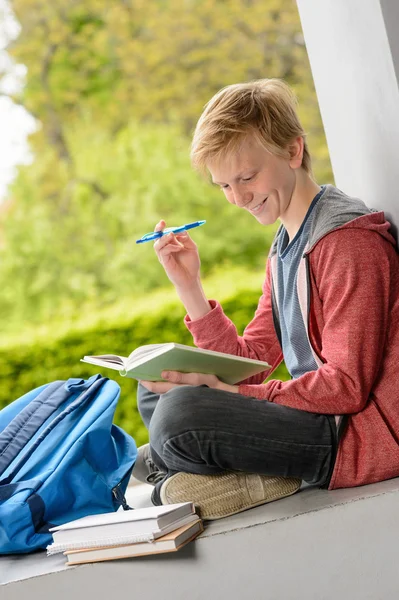 Junge liest Buch außerhalb der Schule — Stockfoto