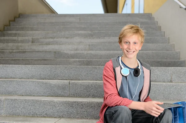 Student s tablet sedí na schodech — Stock fotografie