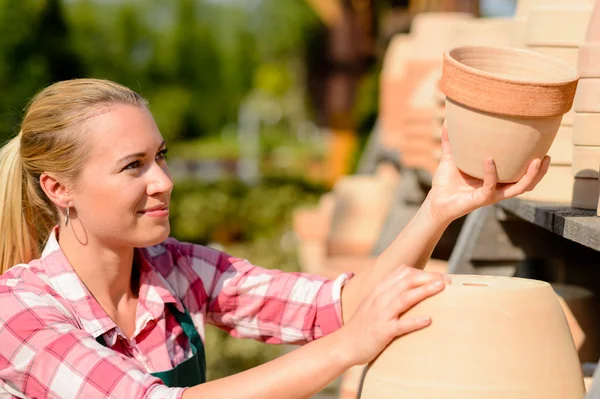 Mujer del jardín poniendo ollas en el estante — Foto de Stock