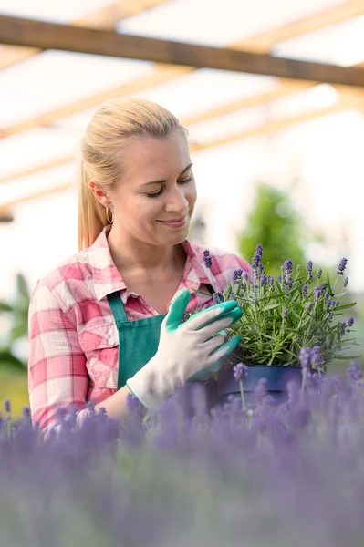 Kvinna med blommor i växthus — Stockfoto