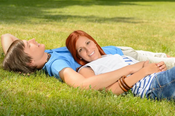 Teenage paar genieten van zon liggen op gras — Stockfoto