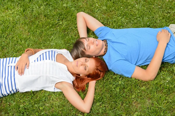 Teenie-Paar liegt auf Gras — Stockfoto