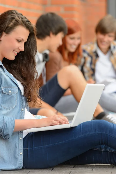 Jóvenes estudiando mujer usando portátil fuera de la universidad — Foto de Stock