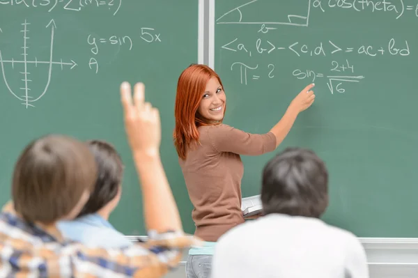 Matematik student skriver på gröna svarta tavlan klasskamrater Stockfoto