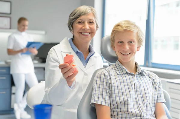 Dospívající chlapec pacienta zubař drží zuby zubní protézy — Stock fotografie