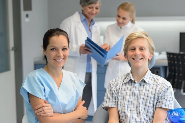 Dentální tým na klinice stomatologie s teenager — Stock fotografie