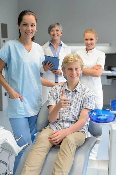 Professional dentist team with boy patient thumbup — Stock Photo, Image