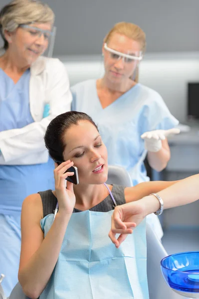 Impatient woman patient on phone at dental clinic — Stock Photo, Image