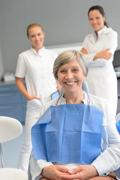 Senior vrouw patiënt met professionele tandarts team Stockfoto