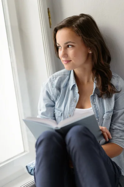 Tonårig flicka sitter med bok — Stockfoto