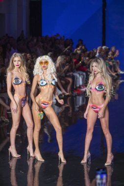 Miami Beach 'teki Faena Forum' da Sanat, Kalpler, Moda Yüzme Haftası 'nda Riskli Dukes Yüzme Moda Şovu için podyumda bir manken yürüyor.