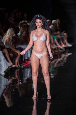 Miami Beach 'teki Faena Forum' da Sanat, Kalpler, Moda Yüzme Haftası 'nda Riskli Dukes Yüzme Moda Şovu için podyumda bir manken yürüyor.