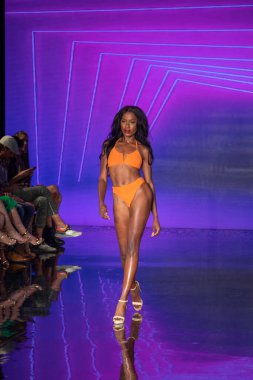 Miami Beach 'teki Faena Forum' da Sanat, Kalpler, Moda Yüzme Haftası 'nda Riskli Dukes Yüzme Moda Şovu için podyumda bir manken yürüyor.