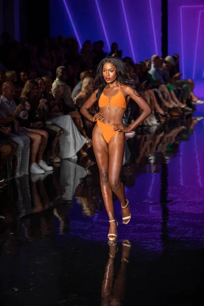 Miami Beach 'teki Faena Forum' da Sanat, Kalpler, Moda Yüzme Haftası 'nda Riskli Dukes Yüzme Moda Şovu için podyumda bir manken yürüyor.