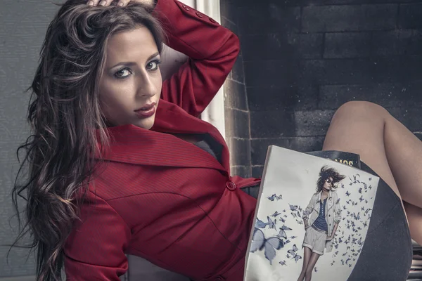 Attractive girl reading a fashion magazine — Stock Photo, Image