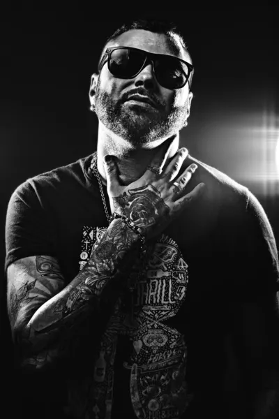 Black and white photo of a handsome man in tattoos — Stock Photo, Image