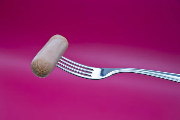 Wiener on metal chromed fork on background — Stock Photo, Image
