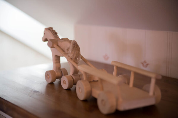Toy horse on small wheels with wagon