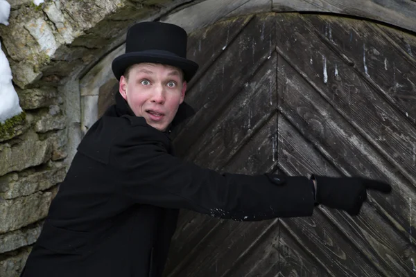 Young man pointing with surprise on door — Stock Photo, Image