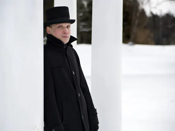 Mann mit Hut verlässt sich auf weiße Säule — Stockfoto