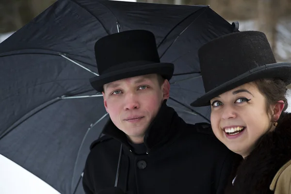 Homme fatigué et femme heureuse sous parapluie — Photo