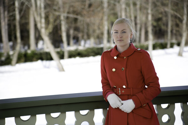 Young woman in red coat at terrace