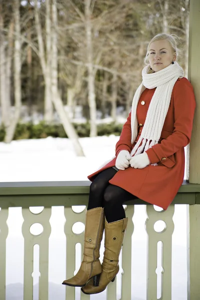 Femme en manteau rouge assis à la frontière — Photo