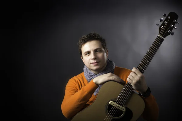 Hombre tranquilo en el fondo posando con la guitarra . — Foto de Stock