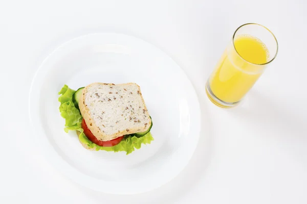Sandwich and glass of juice from above — Stock Photo, Image