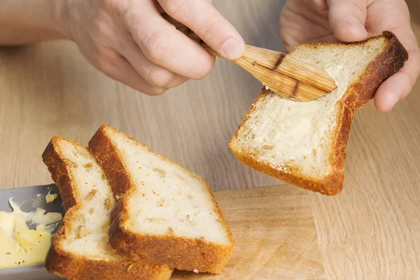 Máslo šíří na krajíc chleba k snídani — Stock fotografie