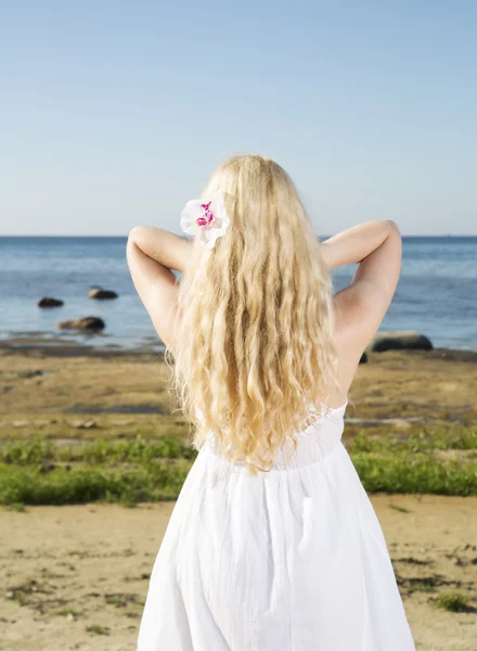Ung kvinna justera hennes guld hårstrån — Stockfoto