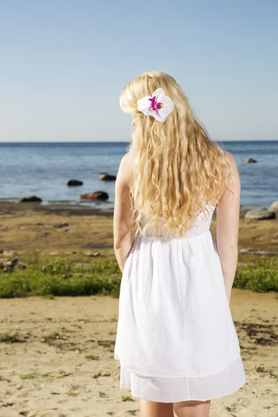 Kvinna med blomma i guld hårstrån — Stockfoto