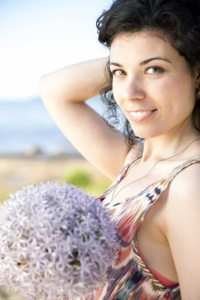 Kvinna med mörkt hår håller lila boquet — Stockfoto