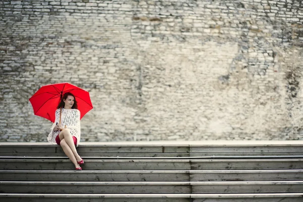 Woman sit with open umbrella at steps — Stock Photo, Image