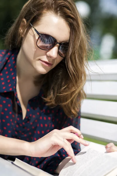 Woman lying on bench and turn page — Stock Photo, Image