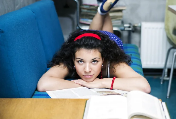 Woman lay on sofa and looks straight — Stock Photo, Image