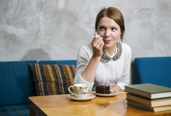 Mulher come bolo com prazer no café — Fotografia de Stock